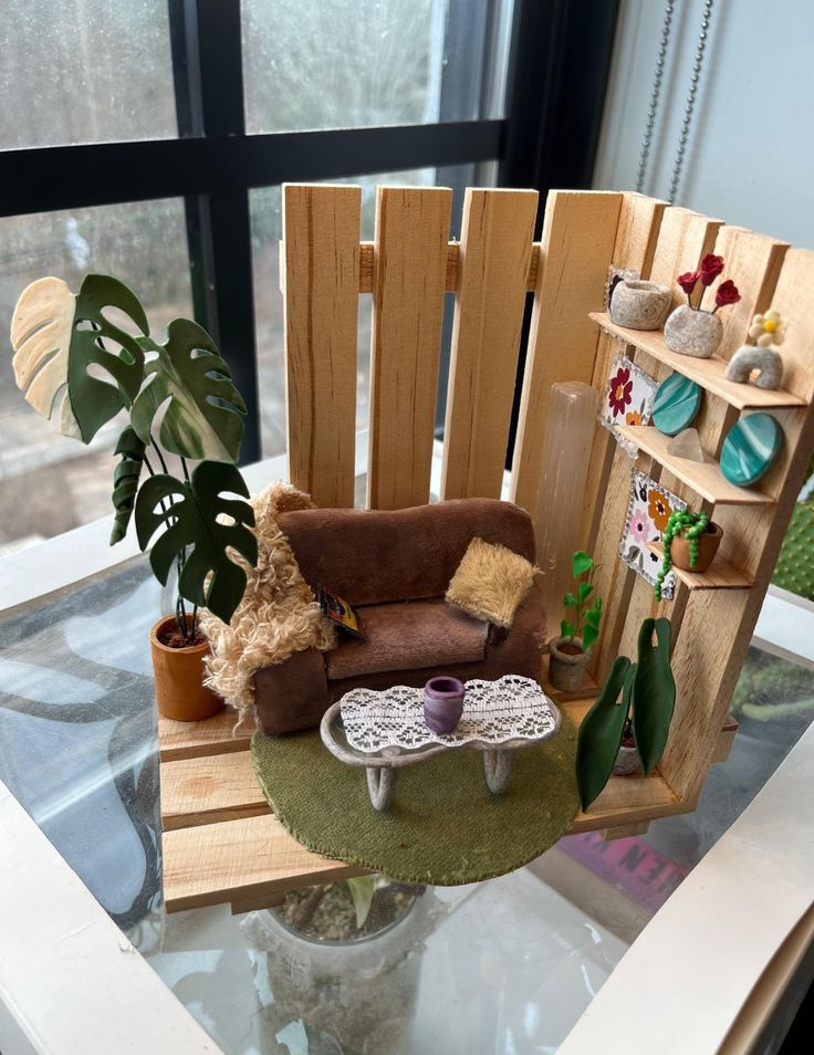 a miniature rocking chair with a teddy bear sitting on it in front of a window