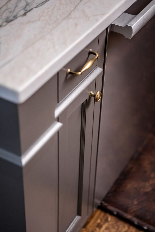 a kitchen with marble counter tops and gold handles