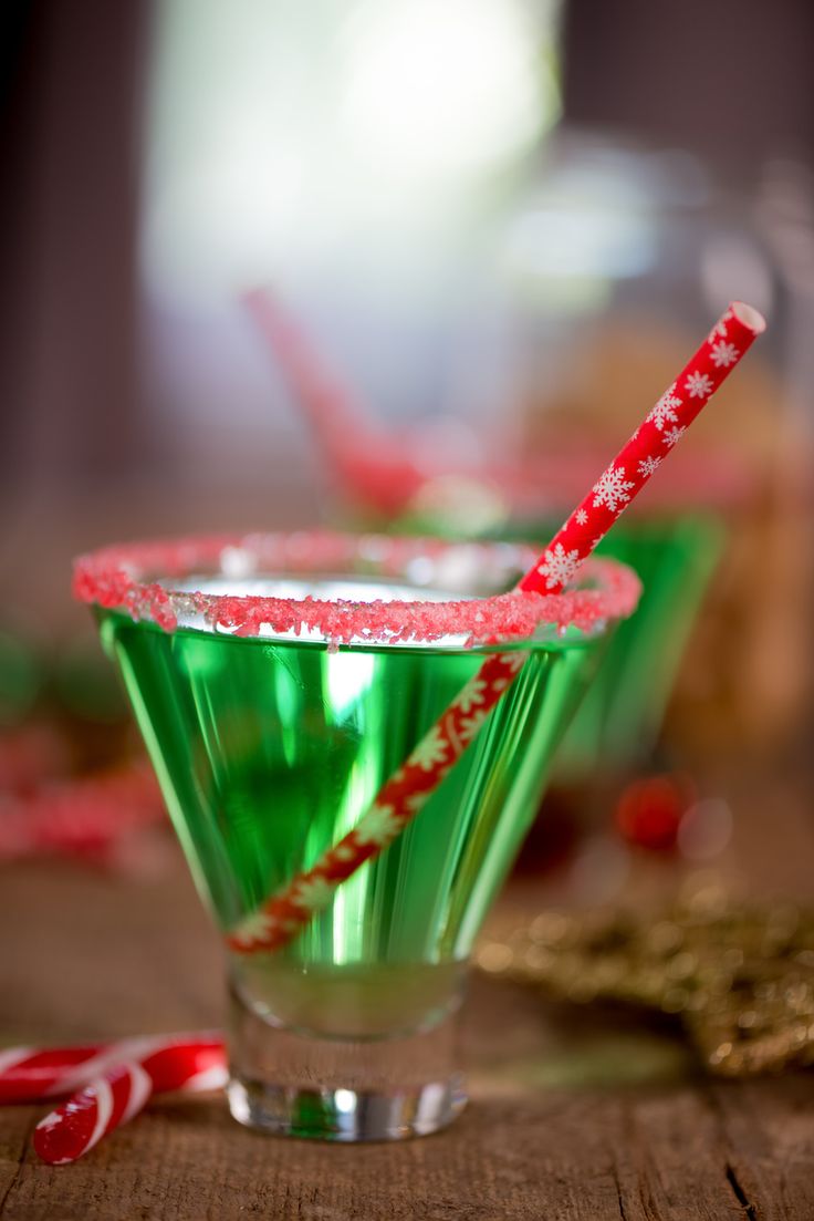 two glasses filled with green liquid and candy canes