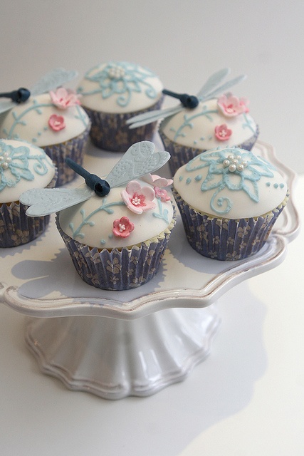 cupcakes decorated with blue and pink flowers on a plate