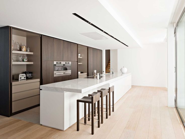 a kitchen with white counter tops and wooden floors