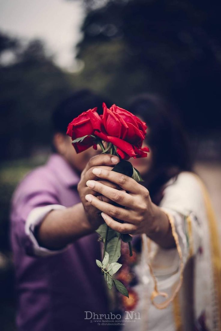 a man holding a red rose in his hands