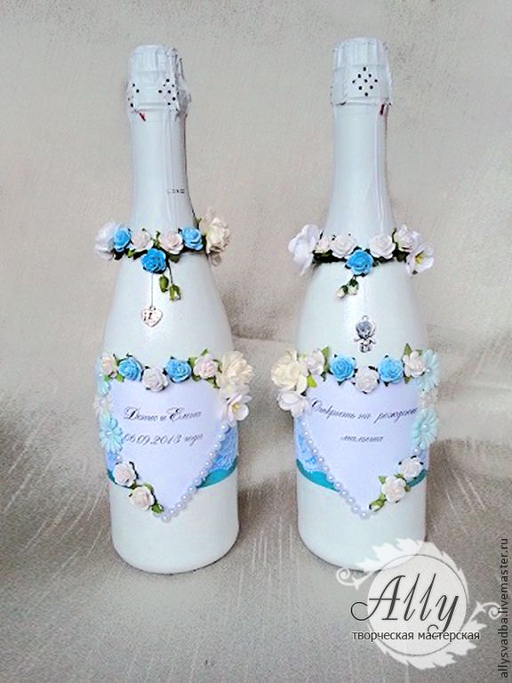 two white wine bottles with blue and white flowers on the top, one is empty