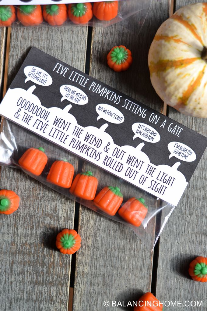 some little pumpkins sitting on a wooden table next to an orange and white pumpkin