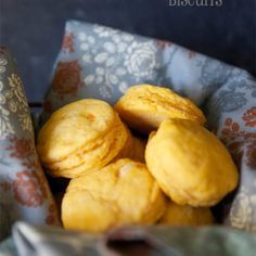 a basket filled with yellow cookies sitting on top of a blue and white table cloth