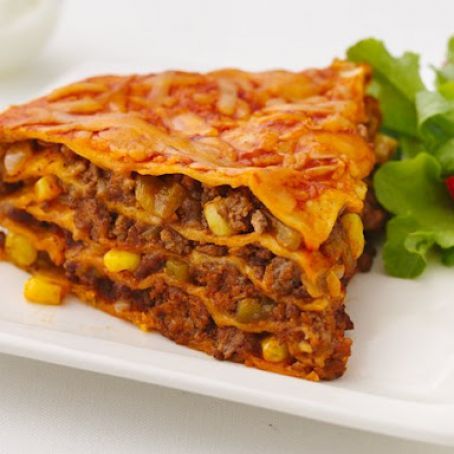 two pieces of lasagna stacked on top of each other in a white plate