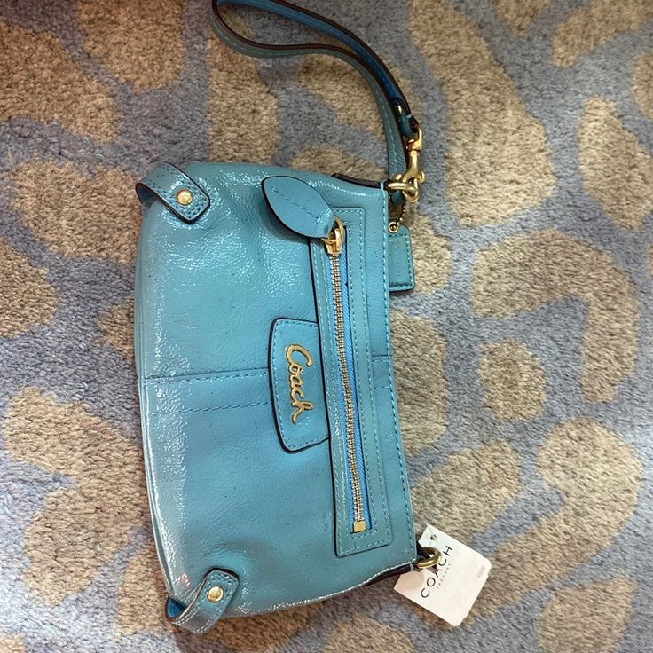 Never Used Powder Blue Patent Leather Coach Wristlet Purse. Perfect For Nights Out. Plenty Of Space For Phone And Handy Wristlet Feature. Two Internal Side Pockets In Main Section And Outer Zipper Closure Pocket. 6”X8.5”X1.5”. See One Small Mark Near Zipper. Also Was Wrapped In Glitter Tissue Paper And Some Of The Glitter Is Still On It. See Pics. Coach Clutch With Zipper Closure, Coach Blue Wristlet For Travel, Blue Pouch Clutch With Zipper Closure, Blue Wristlet With Zipper Pouch For Daily Use, Blue Wristlet With Zipper Pouch For Travel, Blue Coach Clutch For Everyday Use, Coach Blue Clutch For Everyday Use, Blue Travel Wristlet With Removable Pouch, Blue Wristlet With Removable Pouch For Travel