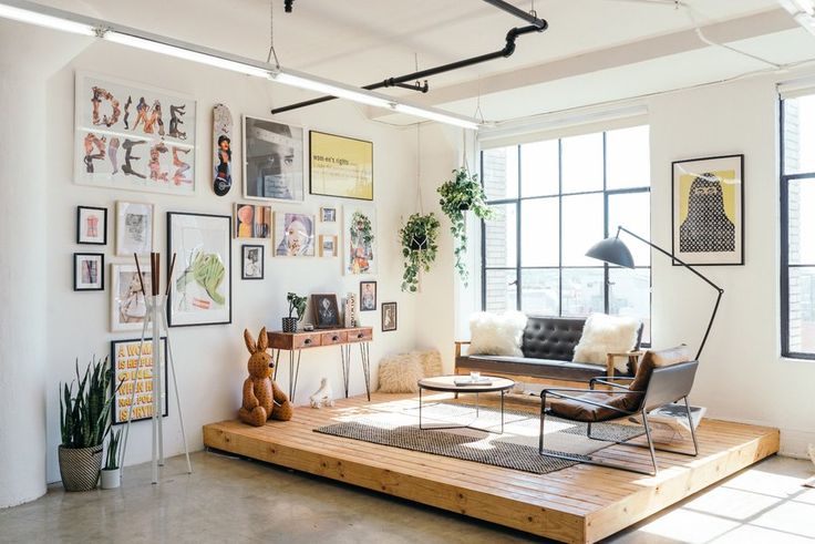 a living room filled with furniture and lots of pictures on the wall next to a window