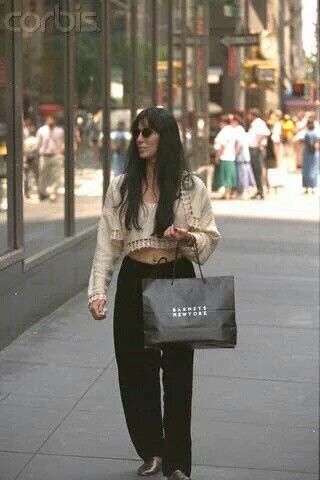 a woman walking down the street with a shopping bag