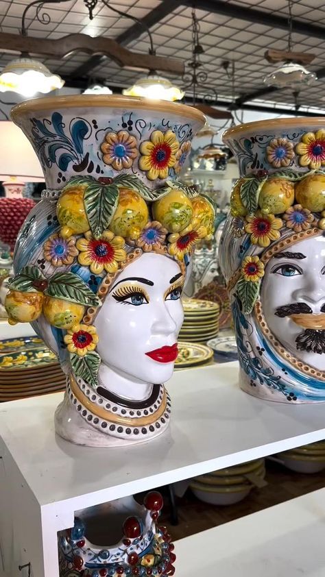 two vases that have faces on them and are decorated with flowers in the middle