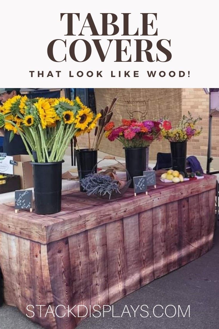 an outdoor table covered in flowers and plants with text overlay that reads, table covers that look like wood