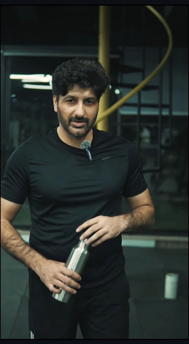 a man in black shirt holding a silver bottle