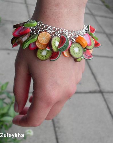 a woman's hand with a bracelet made out of fruits and vegetables on it