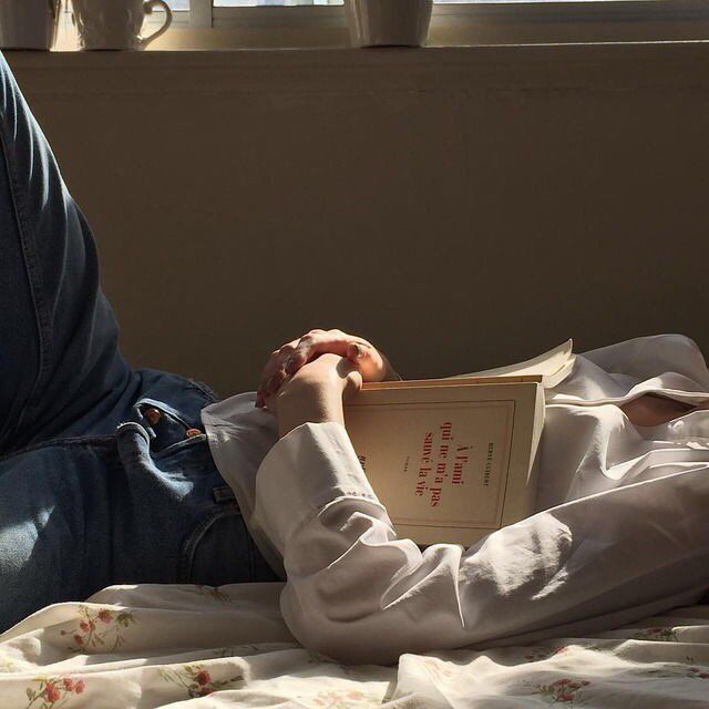 a person laying in bed reading a book