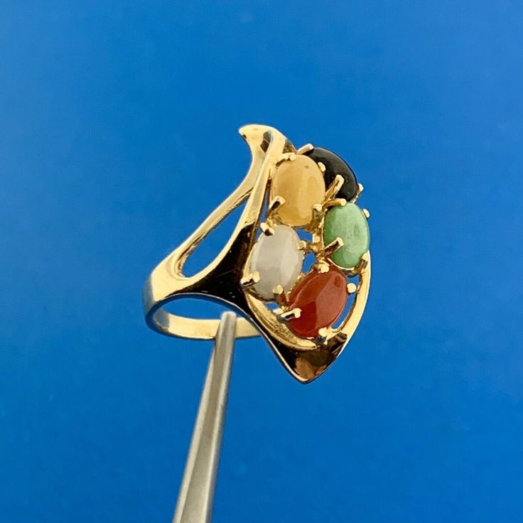 * Vintage 14K Yellow Gold Multi Gemstone Modernist Twist Cocktail Finger Ring * Ring Size: 4.0 * Top of ring measures: 1.0" x 1/2" * Height: 1/2" * Band width: 2.0 mm * Jadeite oval cabochon measures approximately 5.50 mm x 4.0 mm * Jasper oval cabochon measures approximately 5.50 mm x 4.0 mm * Agate oval cabochon measures approximately 5.50 mm x 4.0 mm * Carnelian oval cabochon measures approximately 5.50 mm x 4.0 mm * Black Onyx oval cabochon measures approximately 5.50 mm x 4.0 mm * Ring weight: 4.5 tgw * Marked: 14K * Condition: Great, as pictured. * G2485 5% Restocking Fee    Exported By ExportYourStore :) Collectible 14k Gold Multi-stone Rings, Collectible Multi-stone 14k Gold Rings, Modern Gold Multi-stone Sapphire Ring, Modern Gold Sapphire Ring With Multi-stone, 14k Gold Multi-stone Opal Ring, Yellow Gold Multi-stone Ruby Ring, Unique Multi-stone Ruby Ring In Yellow Gold, Multi-stone Ruby Ring In Yellow Gold, Yellow Gold Multi-stone Art Deco Jewelry