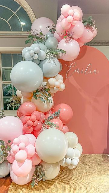 the balloon arch is decorated with pink, white and blue balloons