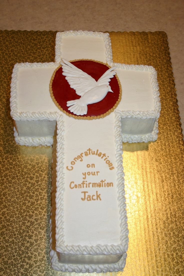 a cake that has a cross on it with a dove on the front and words on the back