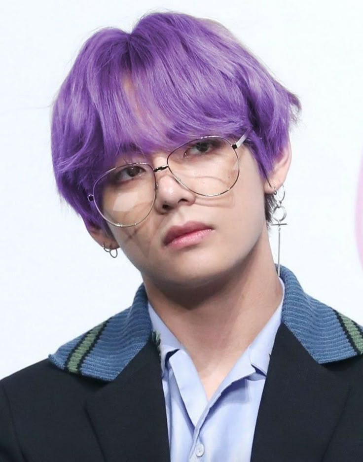 a man with purple hair wearing glasses and a suit