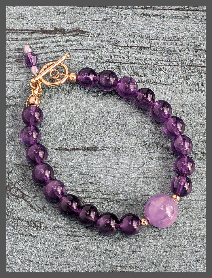 Introducing our Amethyst and Gold Bracelet with a 14K Gold-Filled Toggle Clasp. This exquisite piece combines the captivating beauty of amethyst gemstones with the timeless elegance of gold. The bracelet features amethyst beads and a secure, stylish toggle clasp along with the artist tag and amethyst charm. Elevate your style with this versatile accessory that can be worn alone or layered with other bracelets. The Bracelet measures 7.5" Visit the Amethyst Collection Here Timeless Gold Jewelry With Amethyst, Elegant Adjustable Amethyst Jewelry, Timeless Amethyst Jewelry Gift, Timeless Gold Amethyst Jewelry, Classic Purple Bracelet Jewelry, Elegant Purple Beaded Bracelets With Gemstones, Elegant Lavender Beaded Bracelet For Healing, Adjustable Amethyst Bracelets With Gemstone Accents, Round Amethyst Bracelets With Gemstone Accents