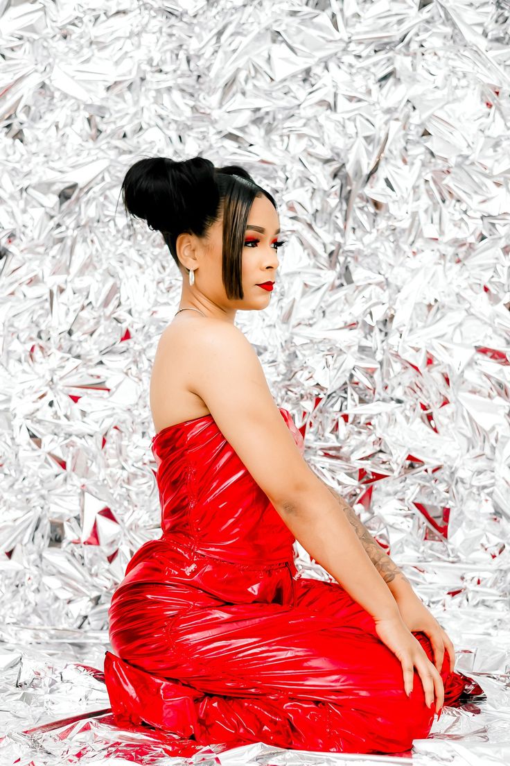 a woman in a red dress sitting on tin foil