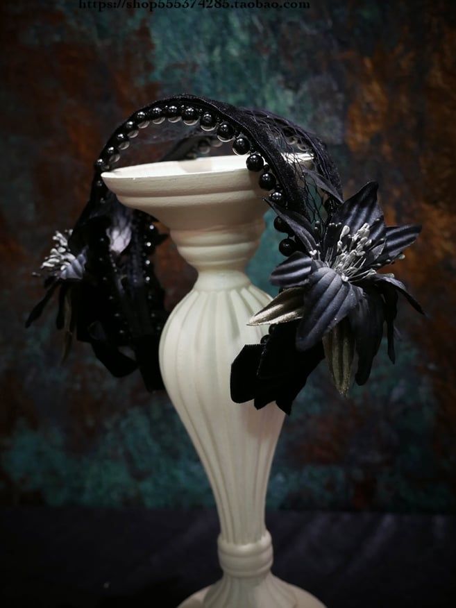 a white vase with black flowers in it