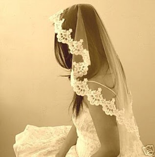 a woman in a wedding dress sitting on a bed with her back to the camera