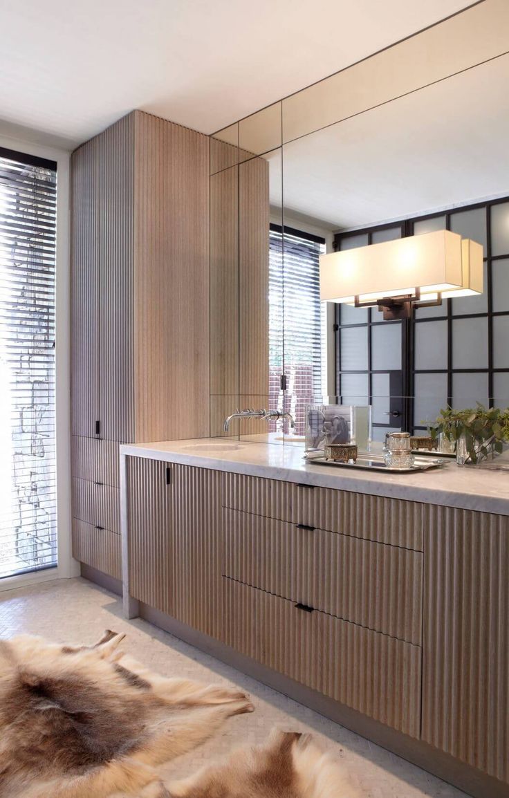 a large bathroom with wooden cabinets and white counter tops, along with a rug on the floor