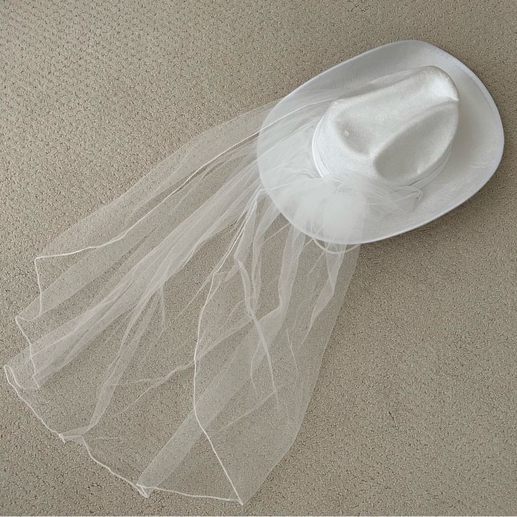 a white hat with veil on the floor