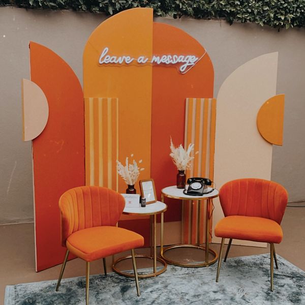 two orange chairs sitting next to each other near a table