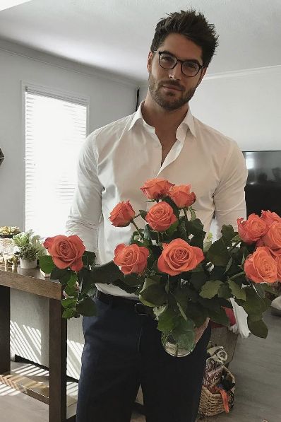 a man holding a bouquet of roses in his hands