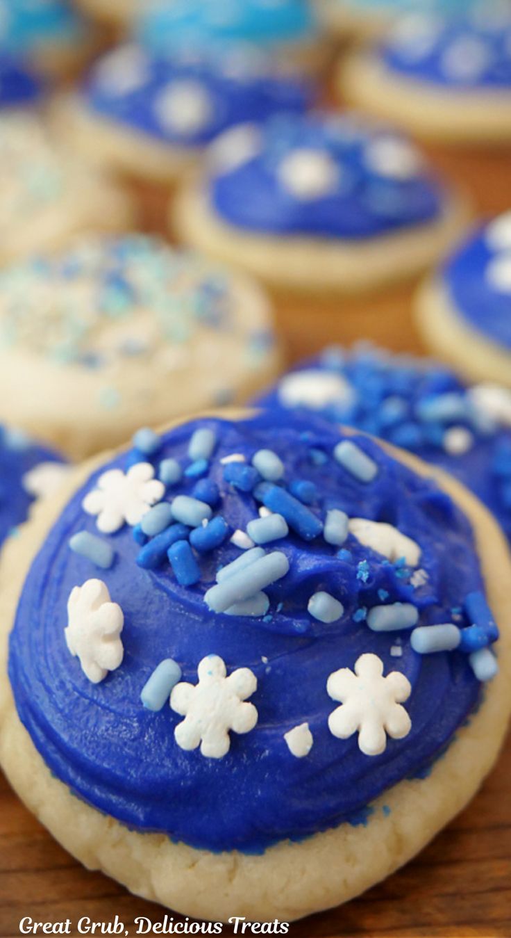 Mini cookies with white, blue, or light blue frosting and sprinkles, sitting on a wooden board. Mini Christmas Cookies, Soft Chewy Sugar Cookies, Mini Sugar Cookies, Gingerbread Cake Recipe, Homemade Buttercream, Christmas Dessert Table, Homemade Buttercream Frosting, Bite Size Cookies, Easy Cupcake Recipes