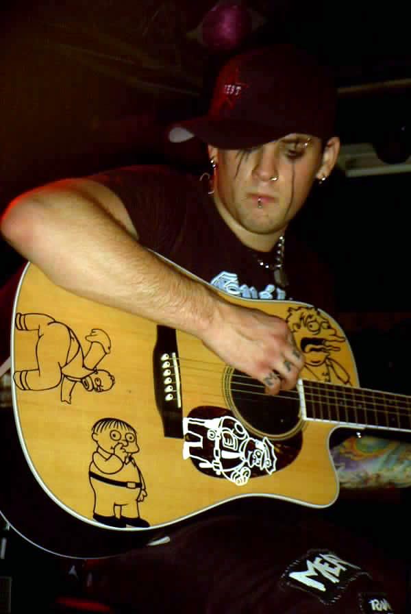 a man is playing an acoustic guitar with cartoon drawings on the back and sides of his neck