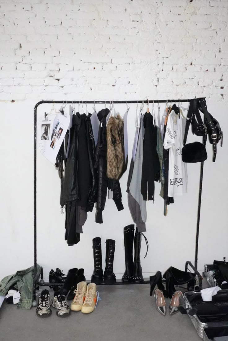 there are many pairs of shoes and coats hanging on the rack next to each other