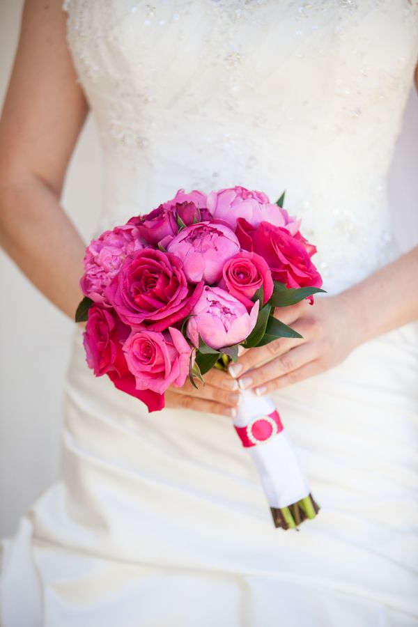 a bride holding a bouquet of pink roses