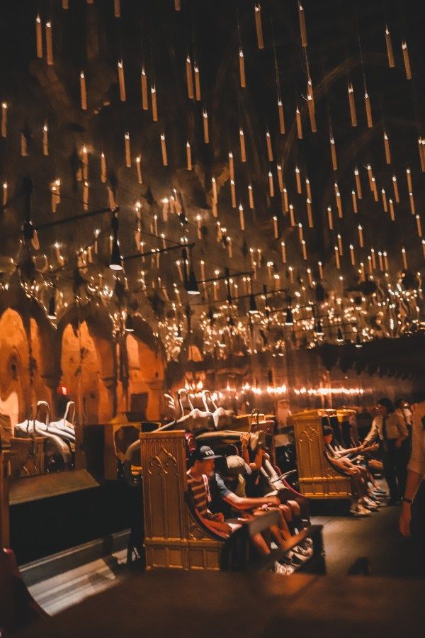 many people are sitting in chairs and lights hanging from the ceiling above them at night