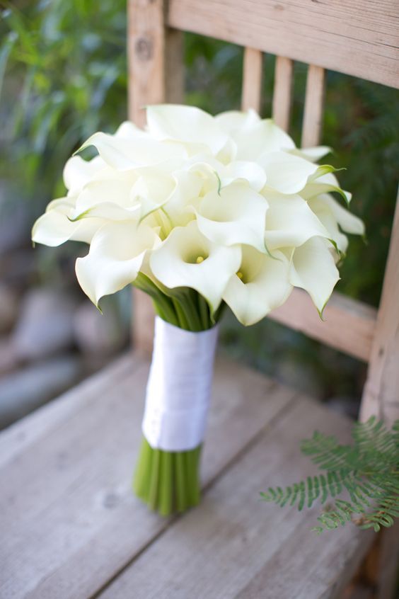 a bouquet of white flowers sitting on top of a wooden chair