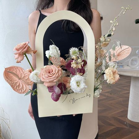 a woman holding up a card with flowers in front of her face and the letter d on it