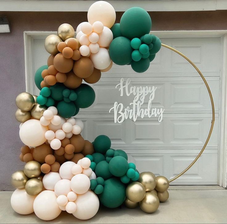 a birthday decoration made out of balloons in front of a garage door