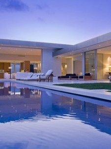 a large swimming pool in front of a modern home