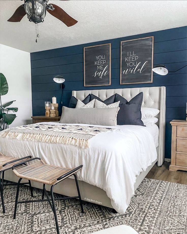 a bedroom with blue walls and white bedding