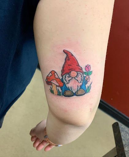 a small gnome tattoo on the arm