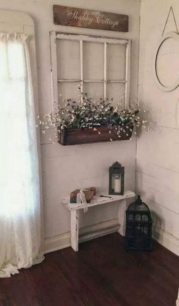 a white bench sitting in front of a window next to a wooden table with flowers on it