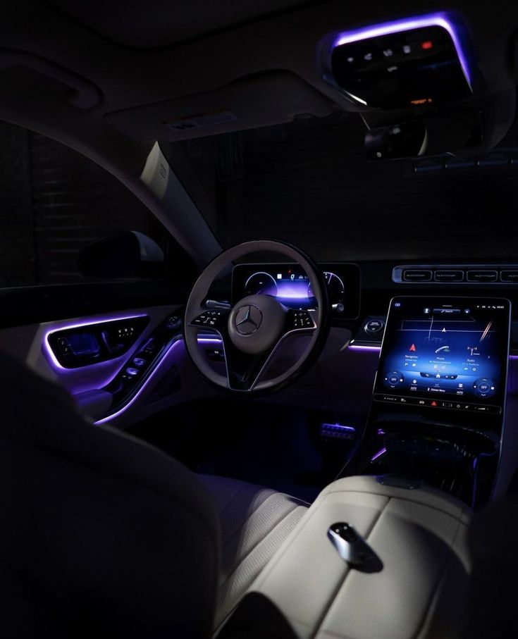 the interior of a car is lit up with blue lights and steering wheel controls,