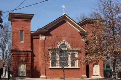 an old red brick church with a cross on top