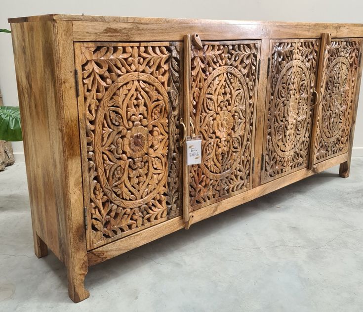 a wooden cabinet with carvings on the doors