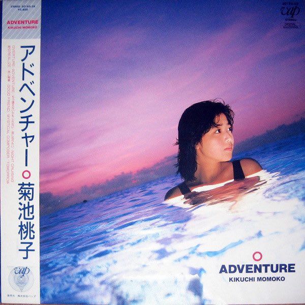 an album cover with a woman swimming in the ocean at sunset or dawn, and japanese writing on it