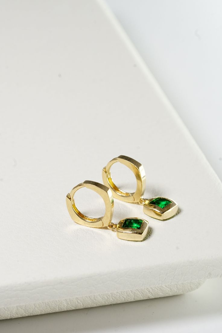 PLX059 Our Green Stone Square Bold Hoop Earrings are meticulously handcrafted in Korea. They beautifully blend classic and contemporary style, making them a unique piece of jewelry. Made from 14K solid gold and adorned with green stones in a square design, these earrings not only offer durability but also emanate a sophisticated charm. Their bold hoop design is perfect for adding a striking and stylish touch to your everyday look or for special occasions. These earrings also make a thoughtful gi Polished Finish Hoop Earrings For Gift, Polished Finish Hoop Earrings As Gift, Polished Finish Dangle Hoop Earrings For Gift, Hoop Huggie Earrings With Bezel Setting As Gift, Fine Jewelry Huggie Earrings With Bezel Setting For Gifts, Hoop Jewelry With Bezel Setting For Gift, Bezel Set Hoop Huggie Earrings As Gift, Fine Jewelry Bezel Setting Hoop Earrings For Formal Occasions, Fine Jewelry Bezel Set Hoop Earrings For Formal Events