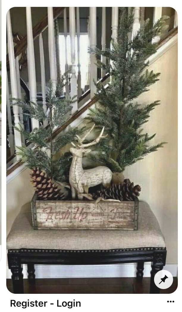 a christmas tree sitting on top of a bench next to a banister with pine cones