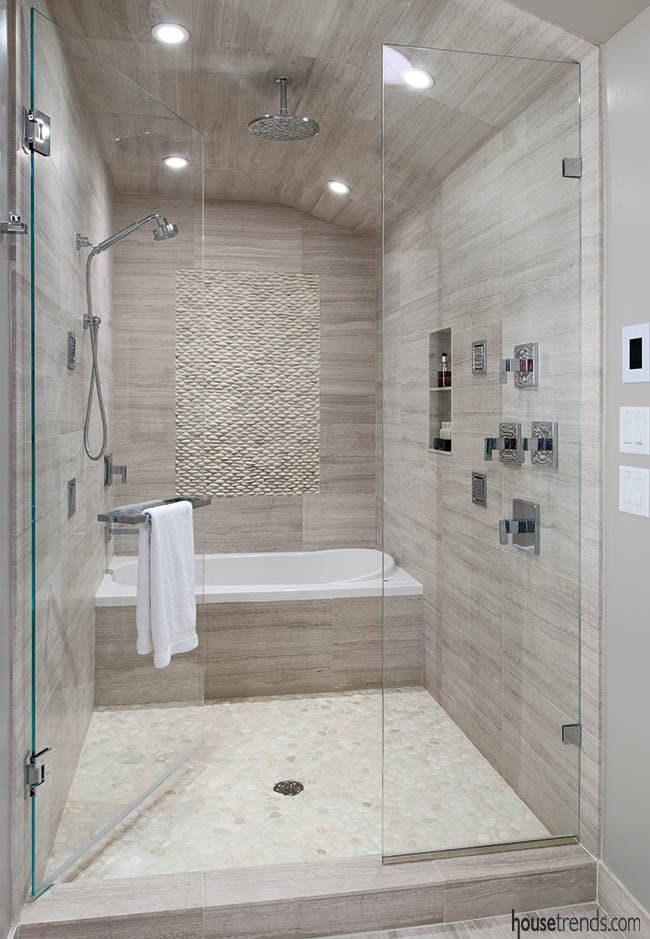 a walk in shower sitting next to a white bath tub under a sky light fixture