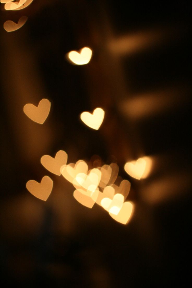 blurry image of lights in the dark with hearts on it's back ground